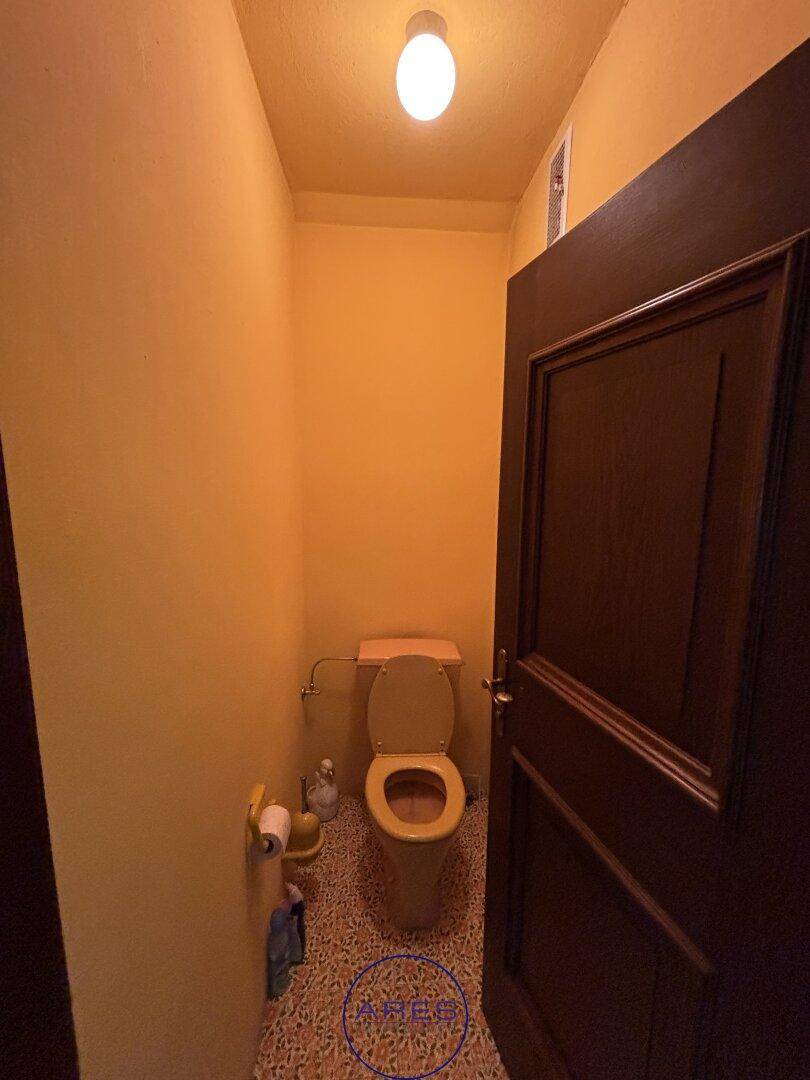 Kleines Gäste-WC mit gelben Wänden und gemusterten Fliesen.