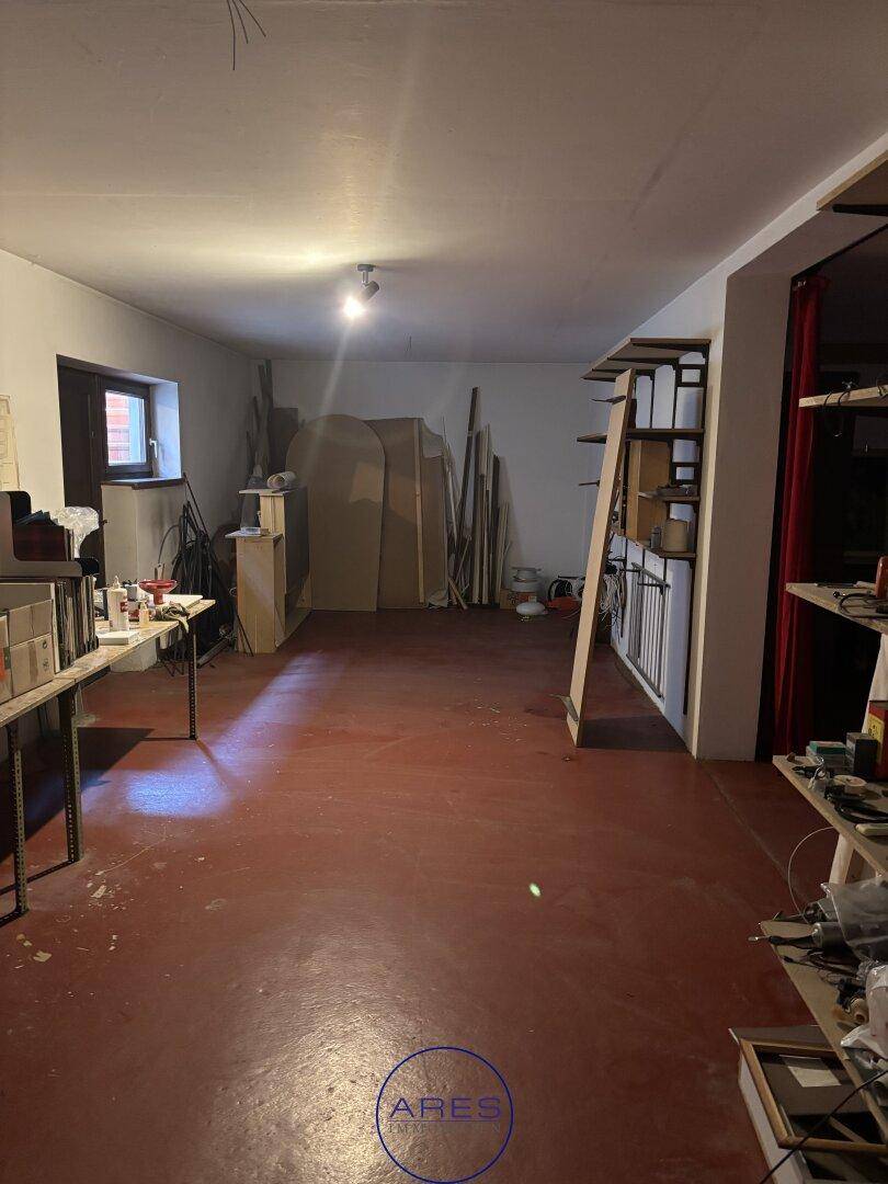 Geräumiger Abstellraum mit rotem Betonboden und Regalen.