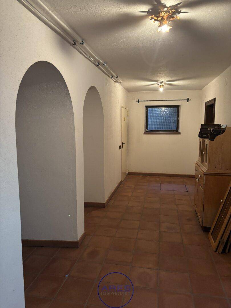 Kellerraum mit Terrakottafliesen und Rundbögen.