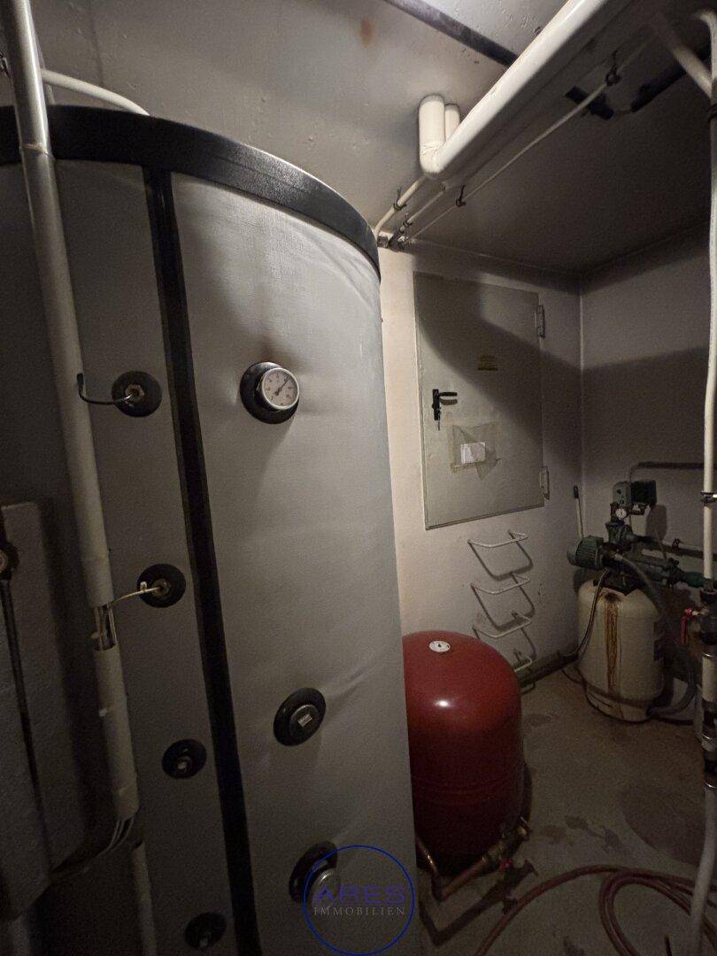Kellerraum mit großem Warmwasserspeicher und komplexen Rohrinstallationen.