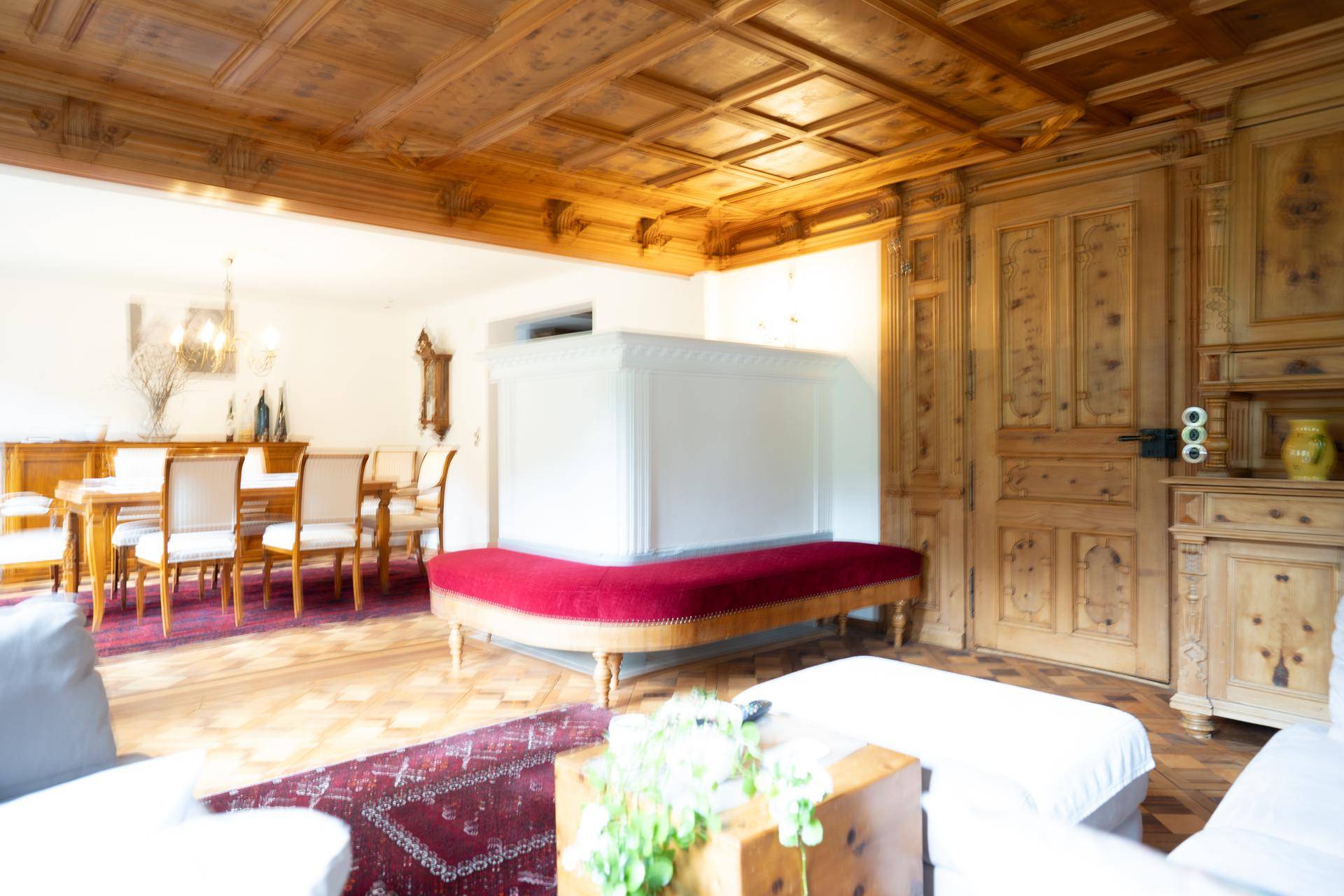 Eleganter Wohn- und Essbereich mit Holzboden, Kassettendecke und traditionellen Holztüren.