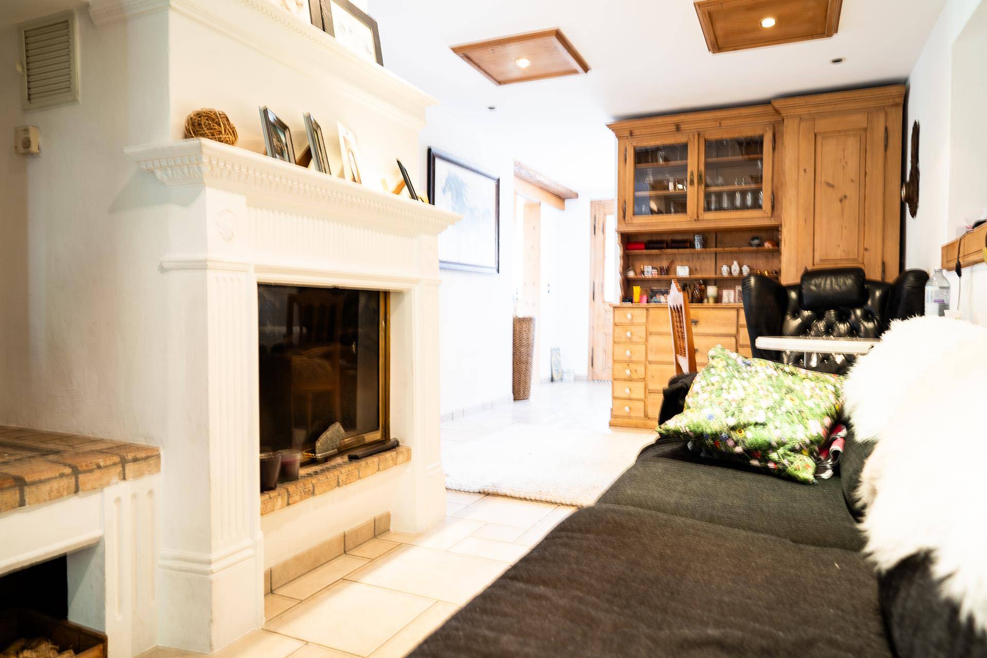 Wohnzimmer mit Kamin, bequemen Sofas und traditionellen Holzmöbeln, schafft eine warme Atmosphäre.