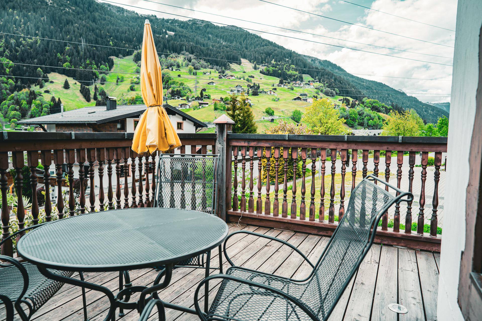 Geräumiger Balkon mit Sitzgelegenheiten und weitem Blick auf die umliegende Berglandschaft.