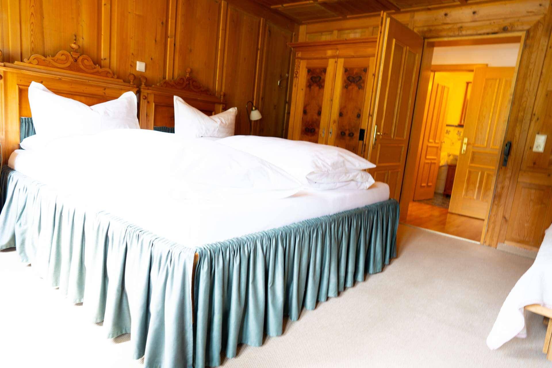 Gemütliches Schlafzimmer mit Holztäfelung, Teppichboden und traditionellem Doppelbett.
