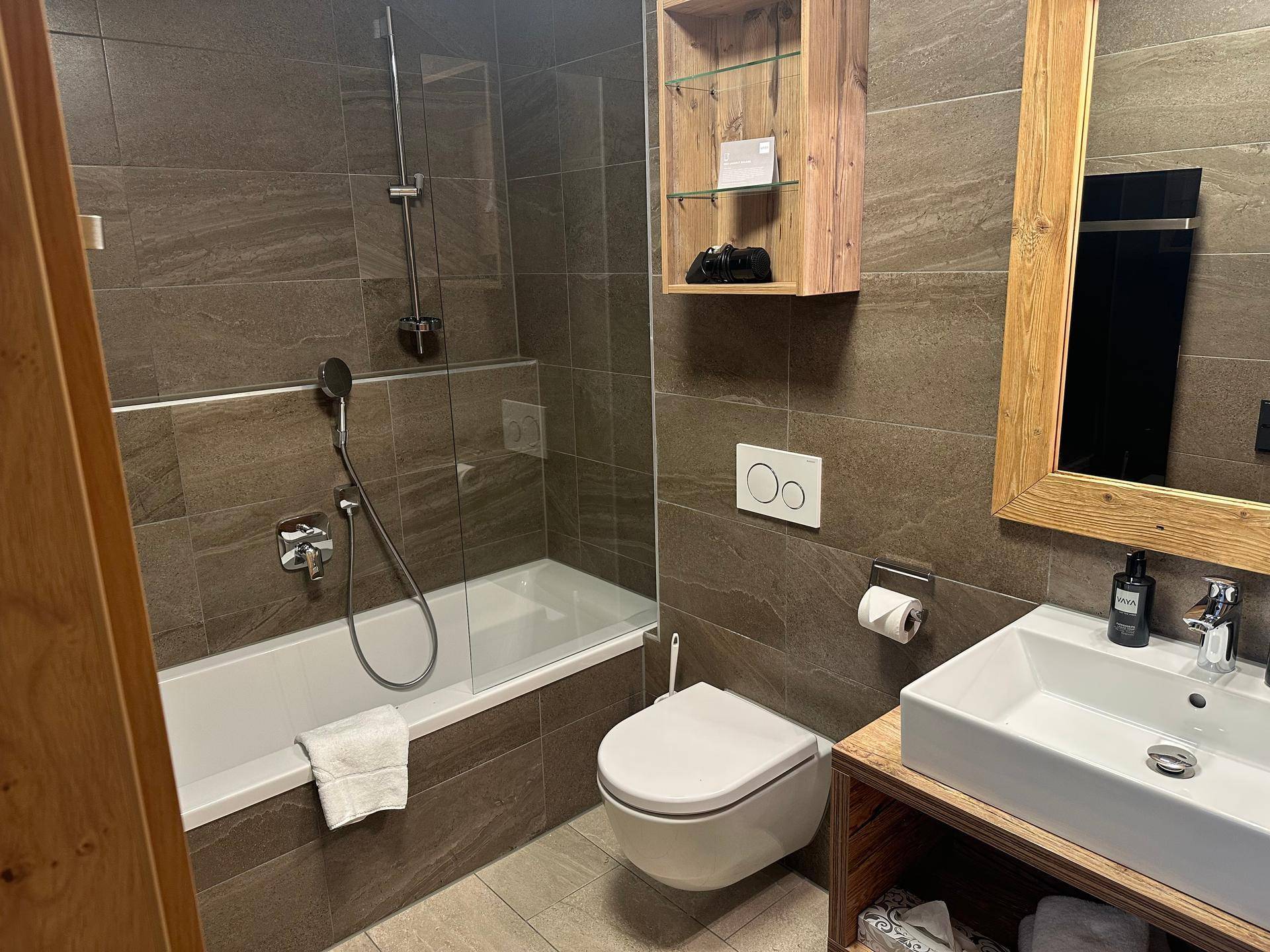 Modernes Badezimmer mit Badewanne, wandhängendem WC und stilvollem Waschbecken.