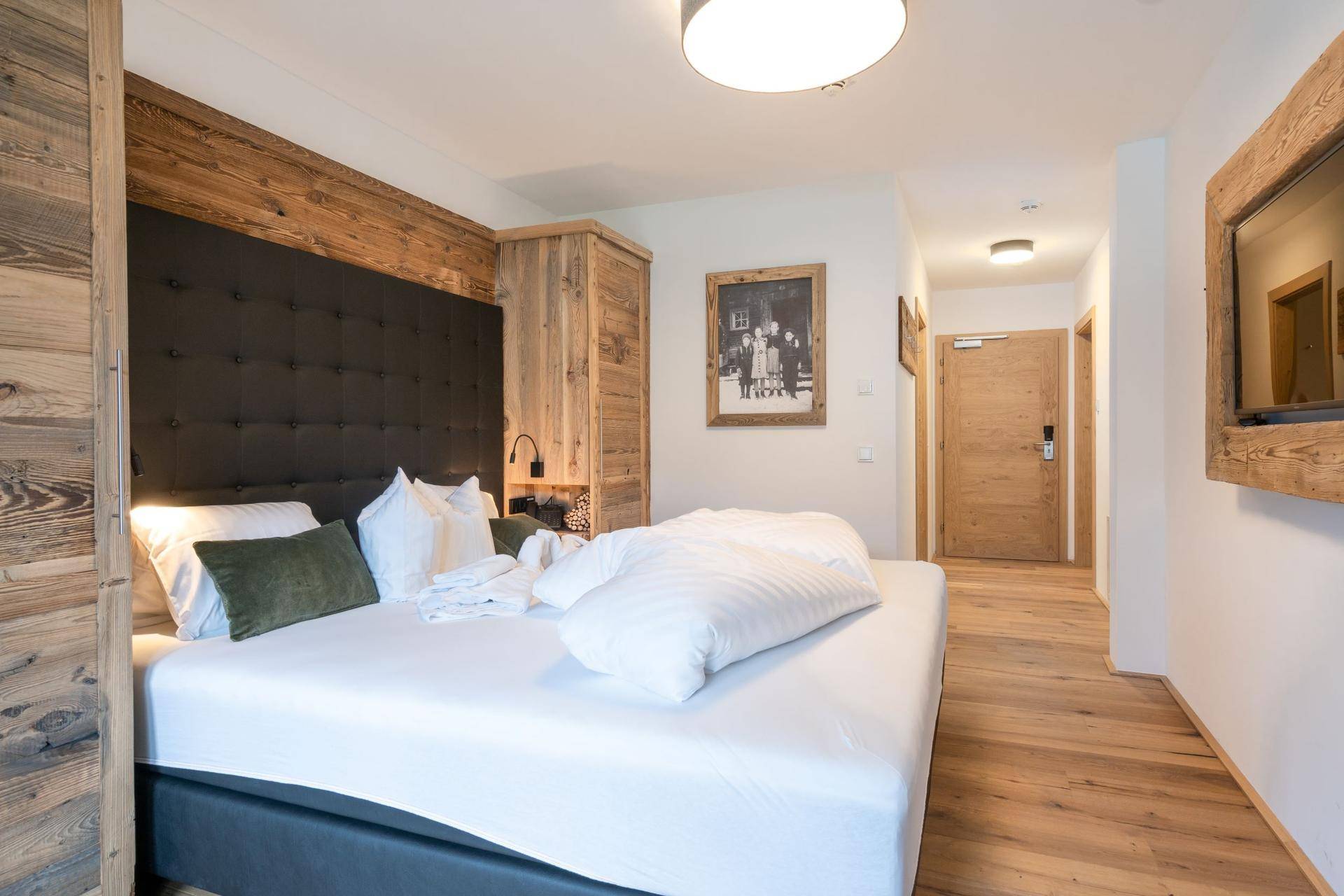 Komfortables Schlafzimmer mit Holzwand, großem Bett und integrierten Holzschränken.