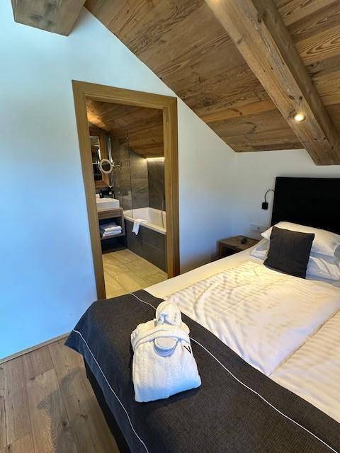 Schlafzimmer mit Doppelbett und direktem Zugang zu einem modernen Badezimmer.