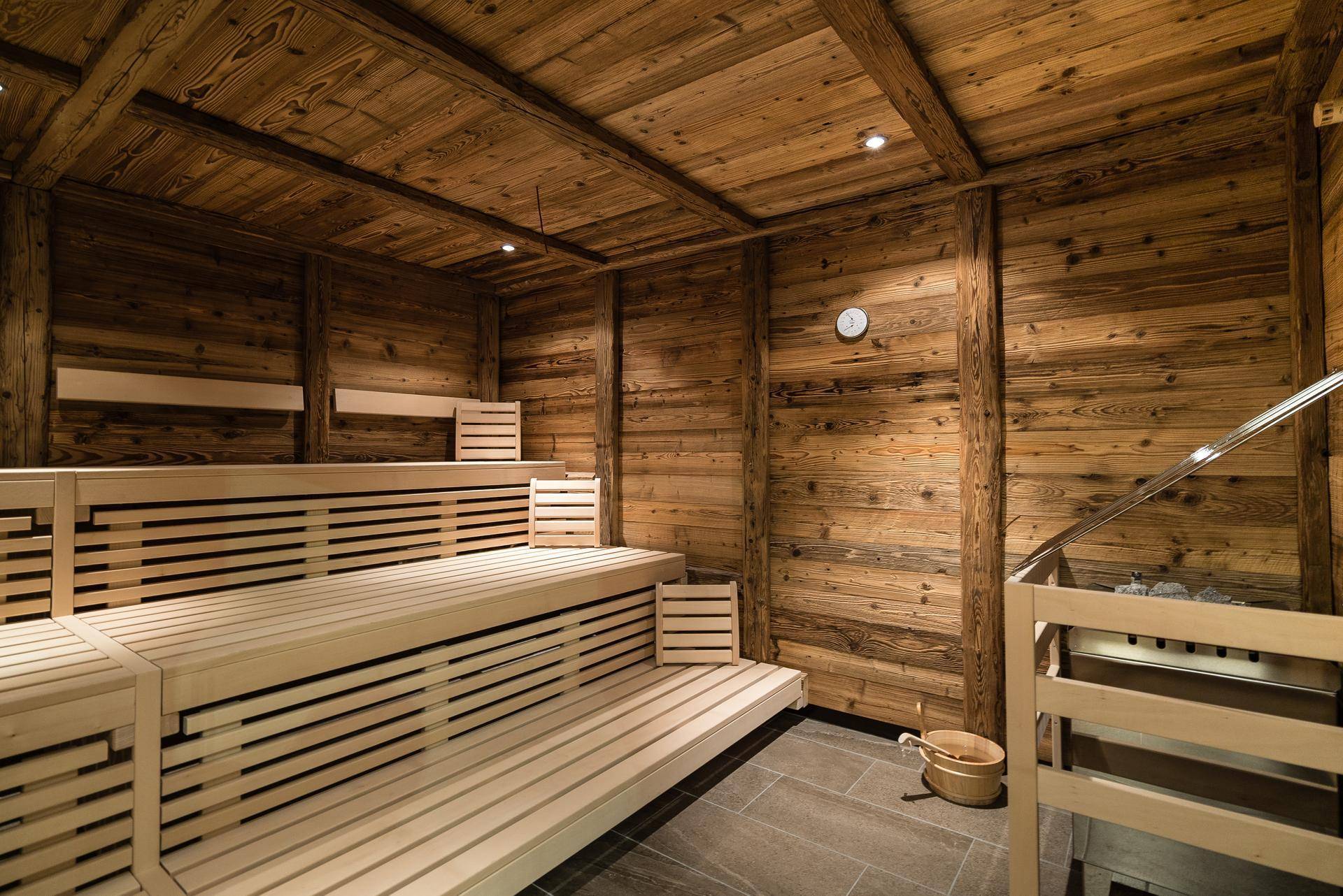 Traditionelle Holzsauna mit mehrstufigen Bänken und einem Saunaofen für entspannende Momente.