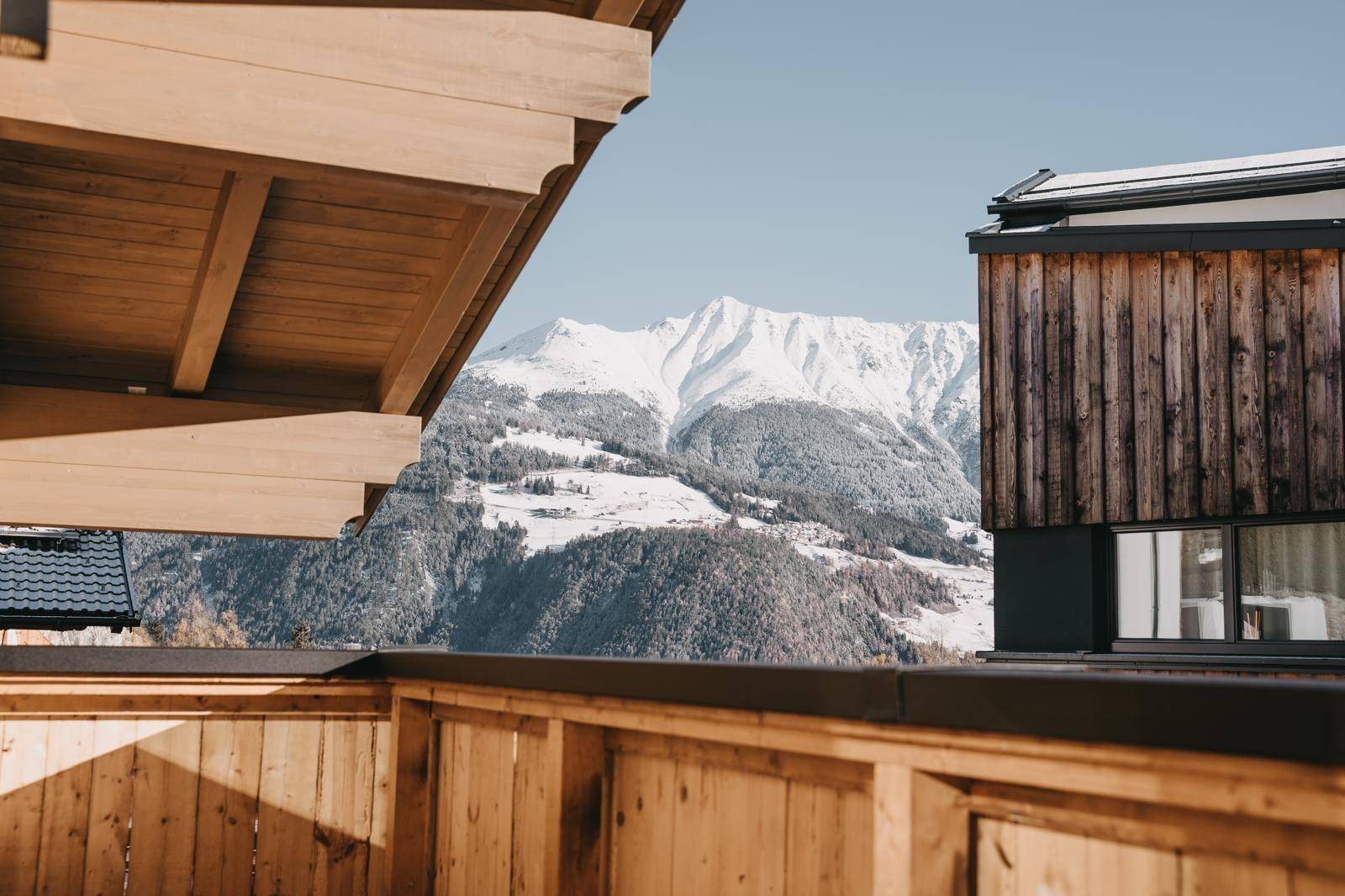 Atemberaubender Blick vom Balkon auf schneebedeckte Berge und die umliegende Natur.