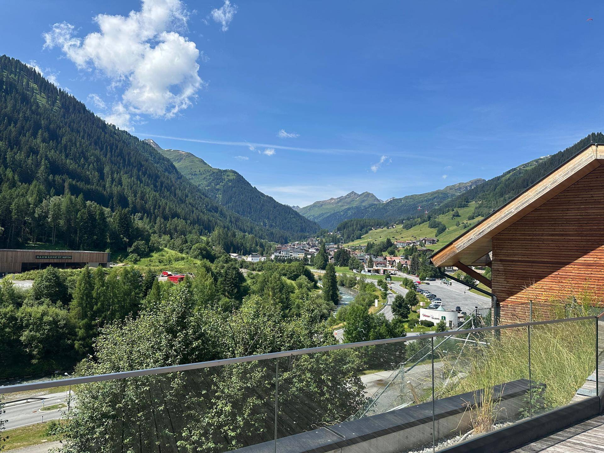 Terrasse mit Holzboden und atemberaubendem Blick auf das Tal und die umliegenden Berge.