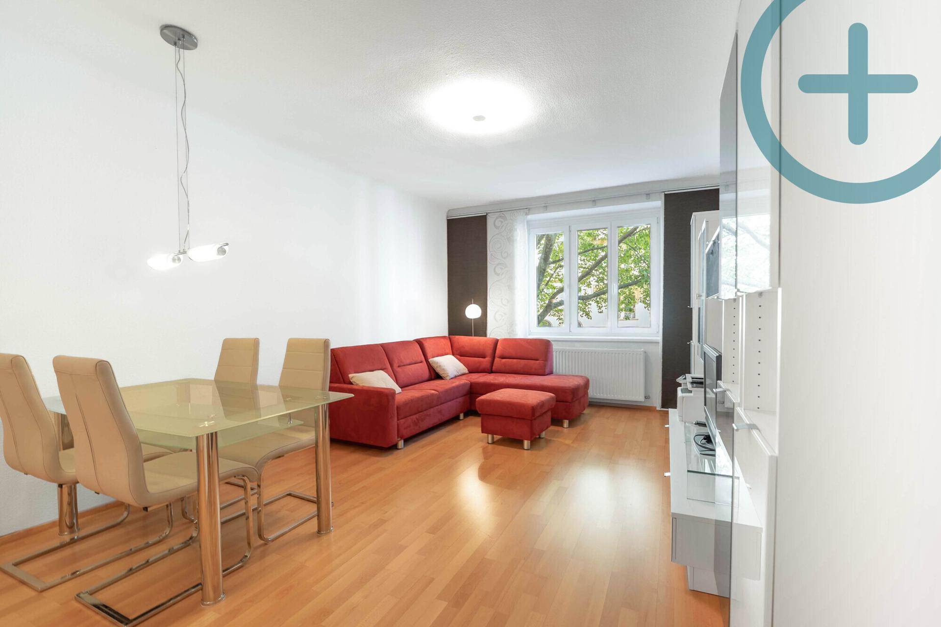 Geräumiges Wohn- und Esszimmer mit hellem Parkettboden und Blick ins Grüne.