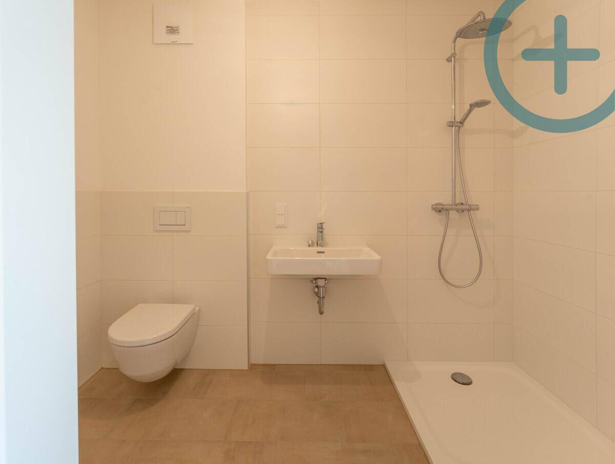Modernes Badezimmer mit wandhängendem WC, Waschbecken und ebenerdiger Dusche.
