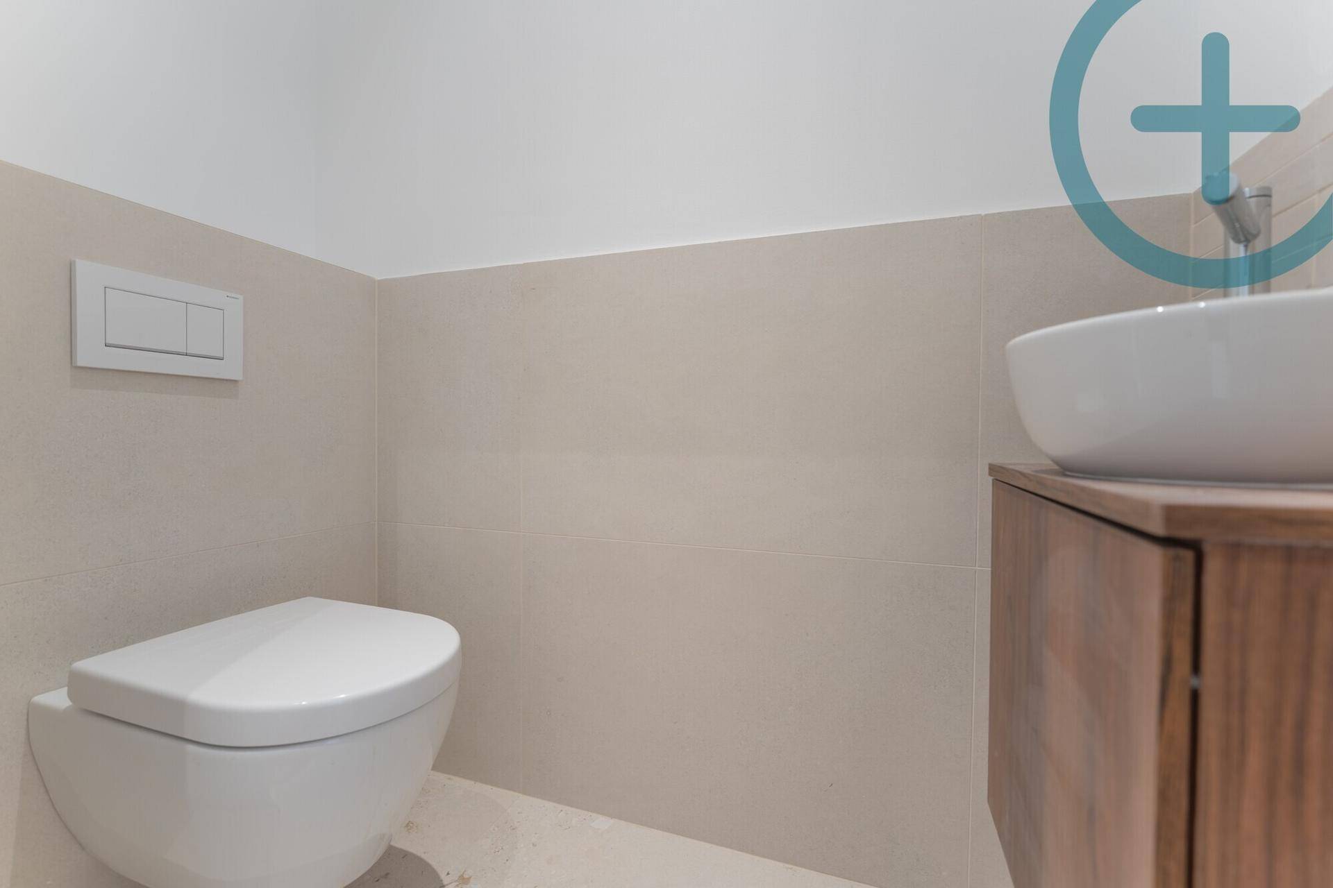 Modernes WC mit wandhängender Toilette und Einzelwaschbecken.