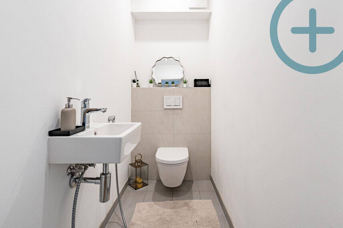 Kleines Gäste-WC mit wandhängender Toilette und modernem Waschbecken.