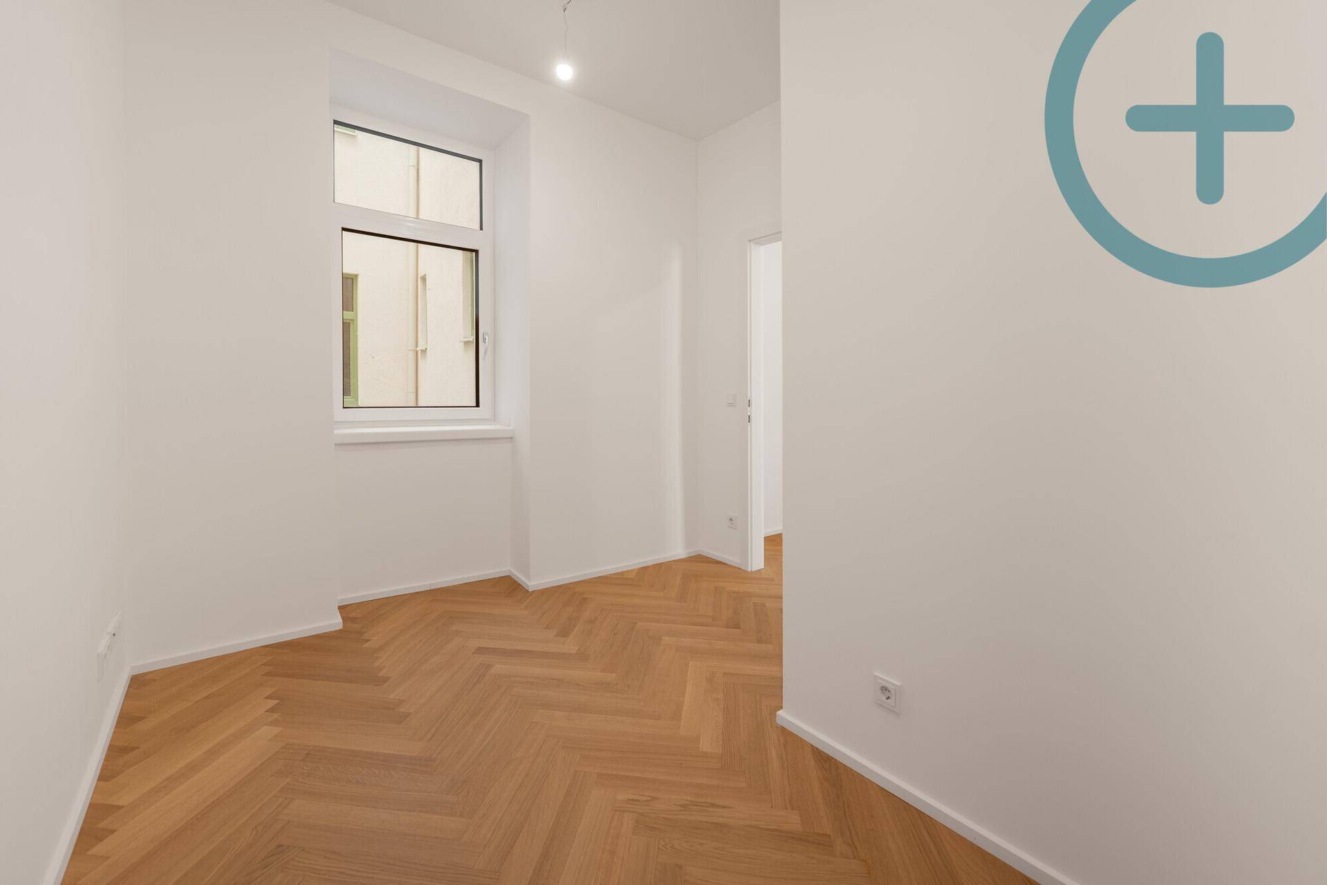 Ruhiges, helles Zimmer mit Fischgrätparkett und einem Fenster, ideal als Schlaf- oder Arbeitszimmer.