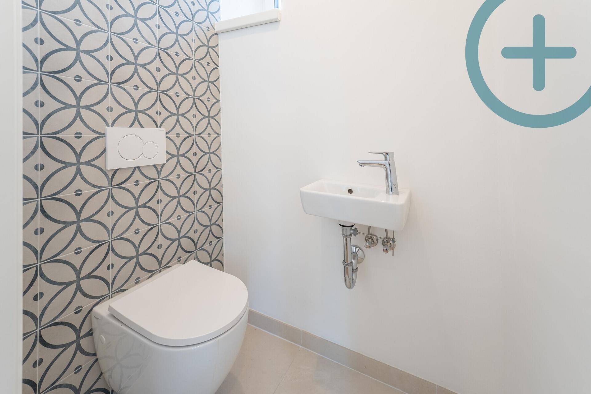 Modernes Gäste-WC mit Wand-WC, kleinem Waschbecken und gemusterter Akzentwand.
