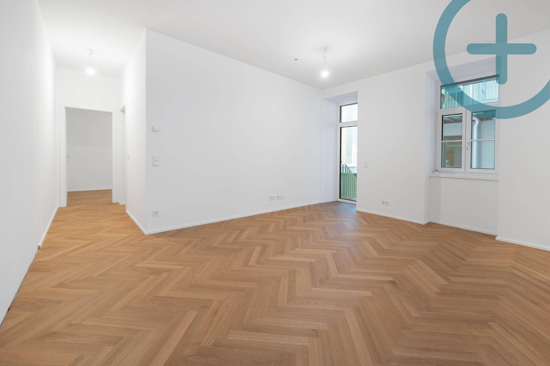 Geräumiges, helles Zimmer mit Fischgrätparkett und Blick nach draußen, bereit zur Einrichtung.