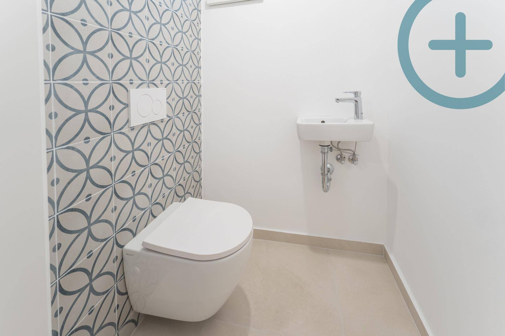 Modernes Gäste-WC mit Wand-WC, kleinem Waschbecken und dekorativen Fliesen.