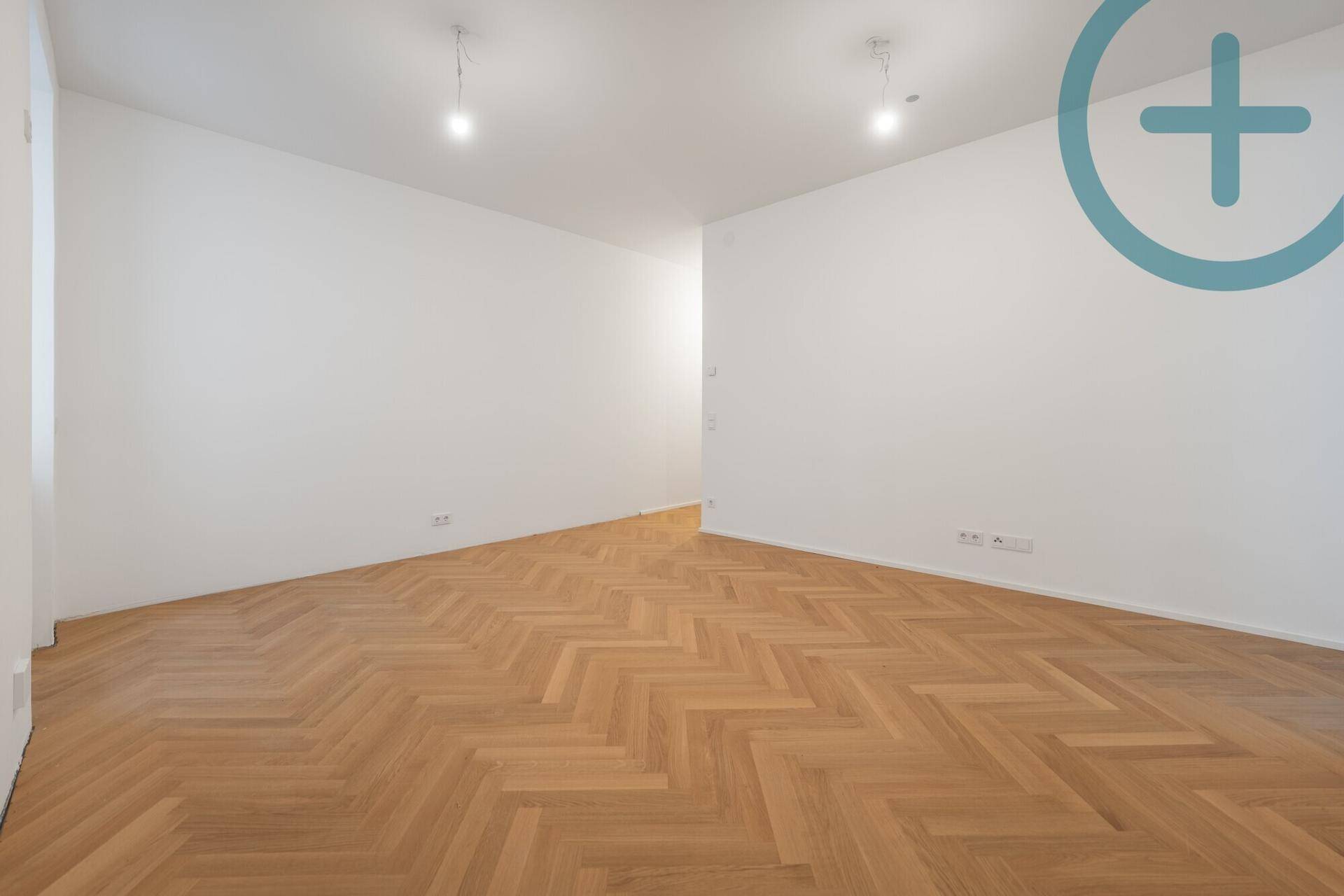 Leeres Zimmer mit hellem Fischgrätparkett und weißen Wänden, bietet viel Gestaltungspotenzial.