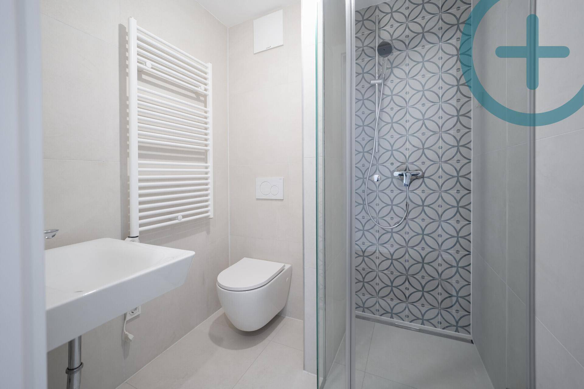 Modernes Badezimmer mit Dusche, wandhängendem WC, Waschbecken und beheiztem Handtuchhalter.