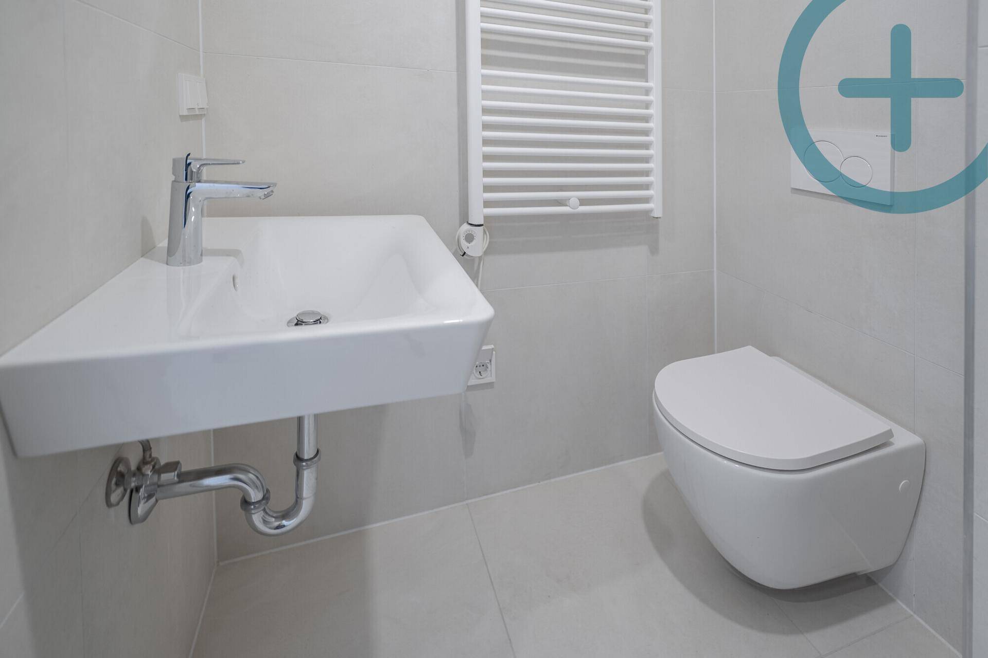 Detailansicht des modernen Waschbeckens und der wandhängenden Toilette im Badezimmer.