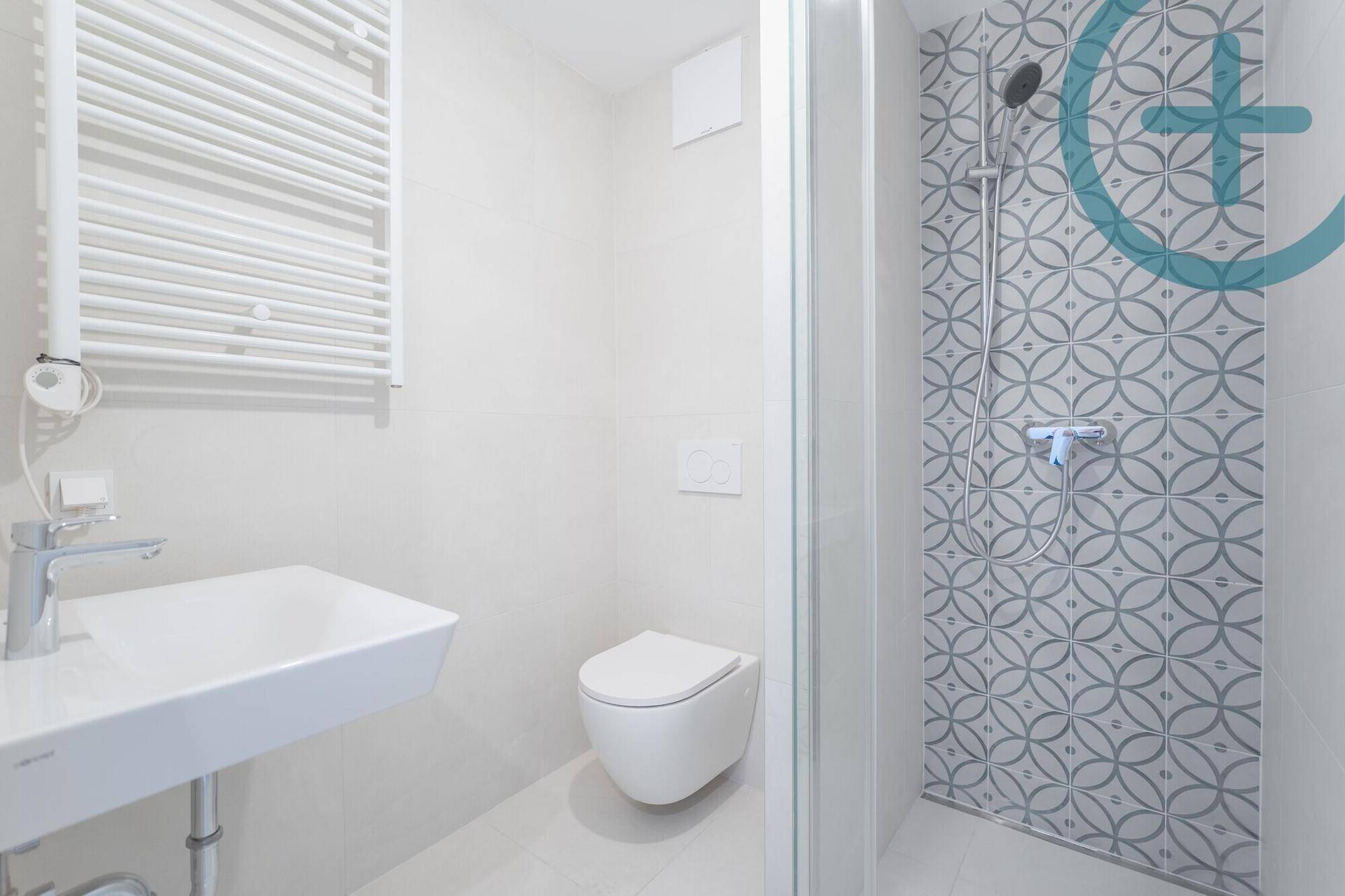 Modernes Badezimmer mit Duschkabine, Wand-WC und beheiztem Handtuchhalter.