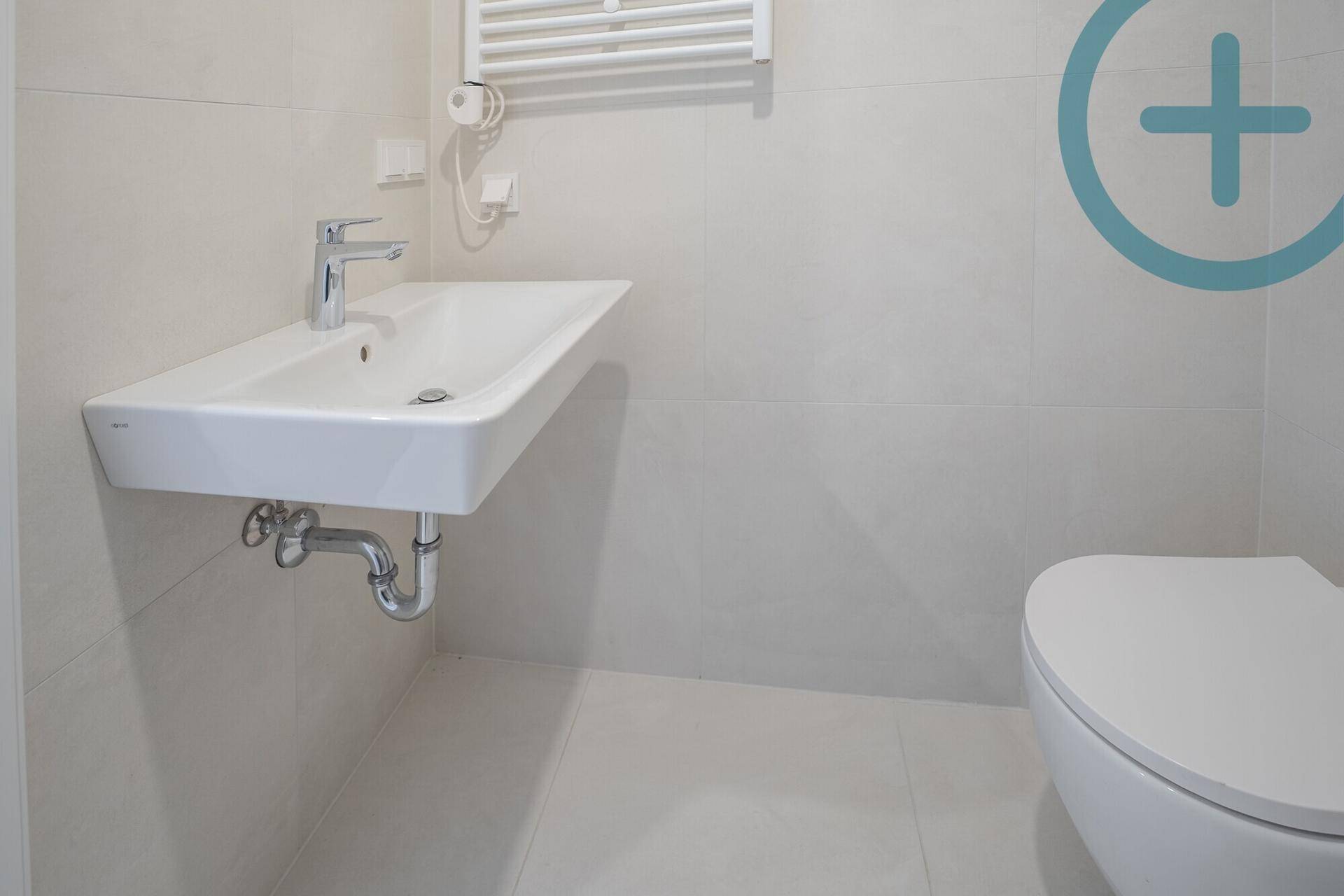 Detailansicht des modernen Waschbeckens und Wand-WCs im Badezimmer.