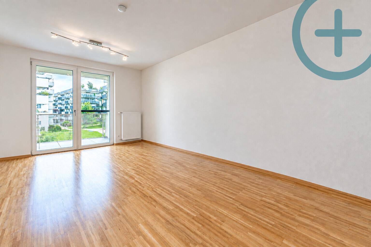 Geräumiger Balkon mit modernen Outdoor-Möbeln und Blick auf die Wohnanlage.