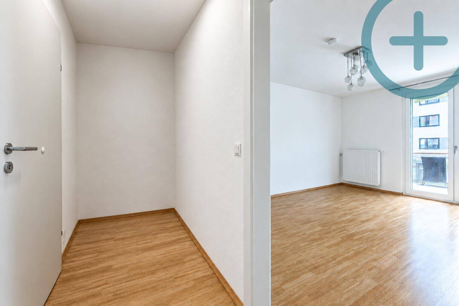 Helles Zimmer mit Parkettboden und moderner Deckenleuchte.
