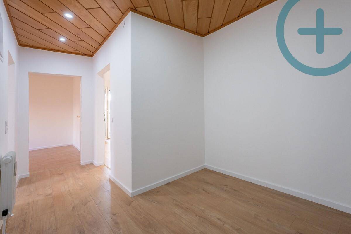 Heller Flur mit Holzdeckenverkleidung und Laminatboden, der zu weiteren Räumen führt.
