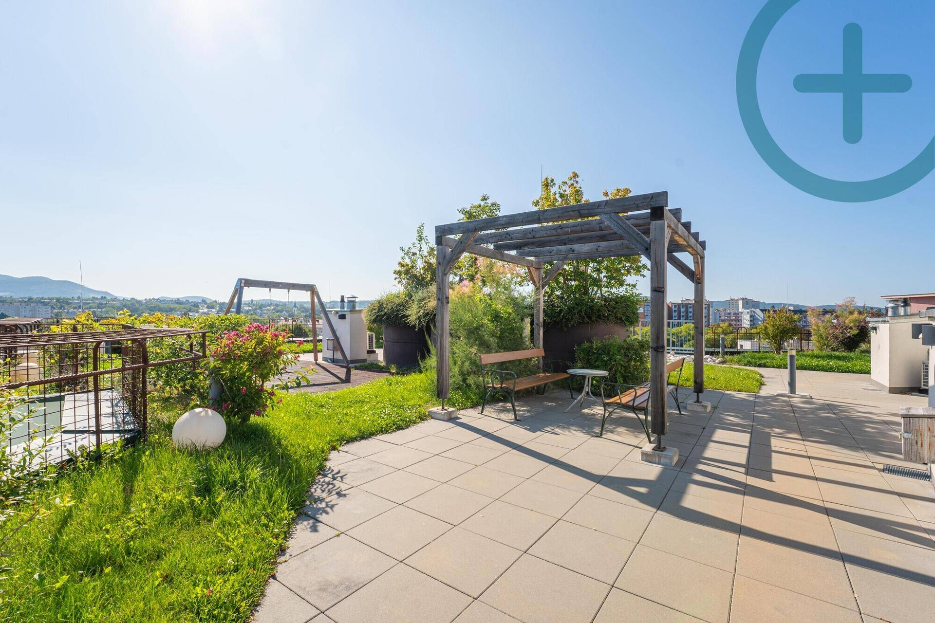 Attraktive Dachterrasse mit Pergola, Sitzgelegenheiten, Grünflächen und Panoramablick.