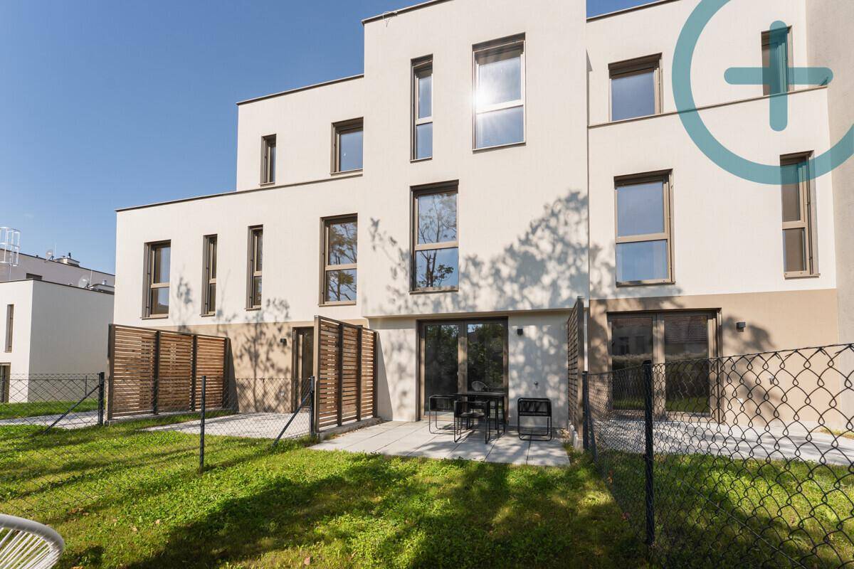 Rückansicht des modernen Gebäudes mit mehreren Terrassen und privaten Gartenbereichen.