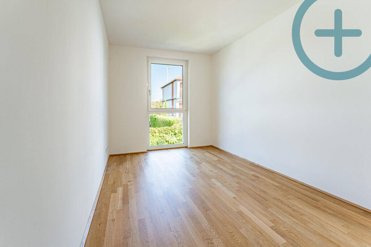 Kleineres Schlafzimmer oder Büro mit Parkettboden und einem Fenster für natürliches Licht.