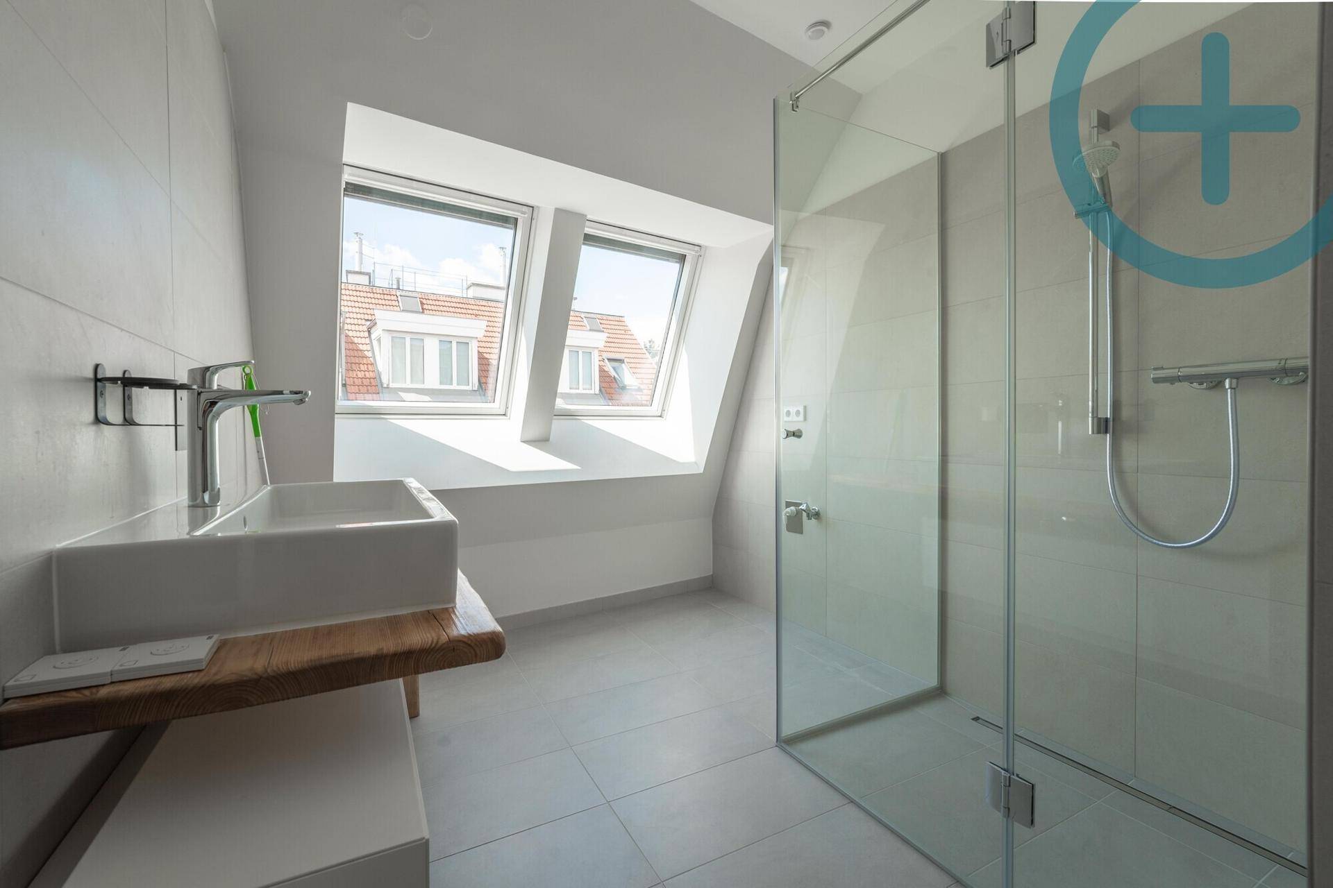 Modernes Badezimmer mit begehbarer Dusche, Einzelwaschbecken und Dachfenstern für natürliches Licht.