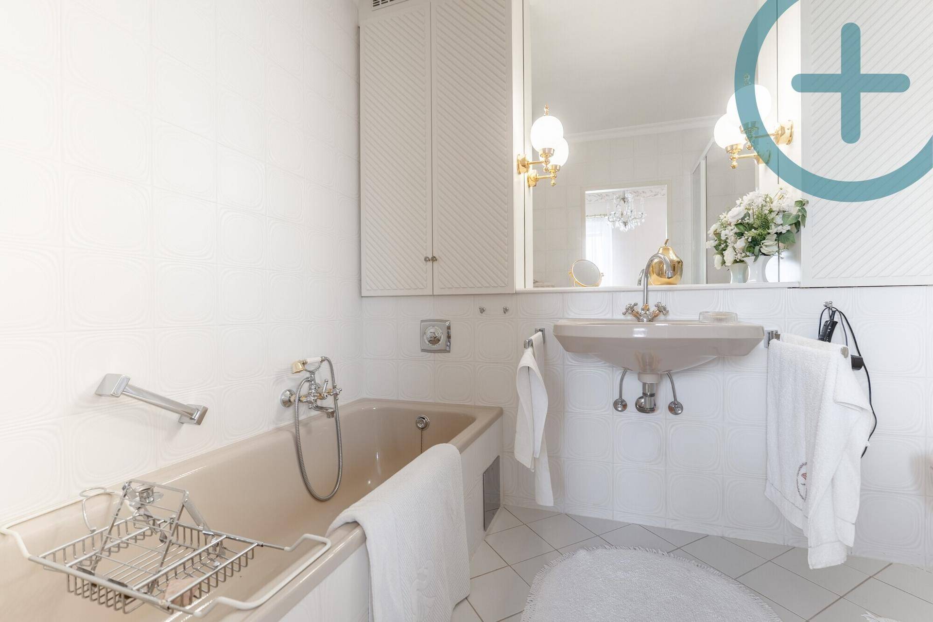 Helles Badezimmer mit weißen Fliesen, Badewanne und einem einzelnen Waschbecken.