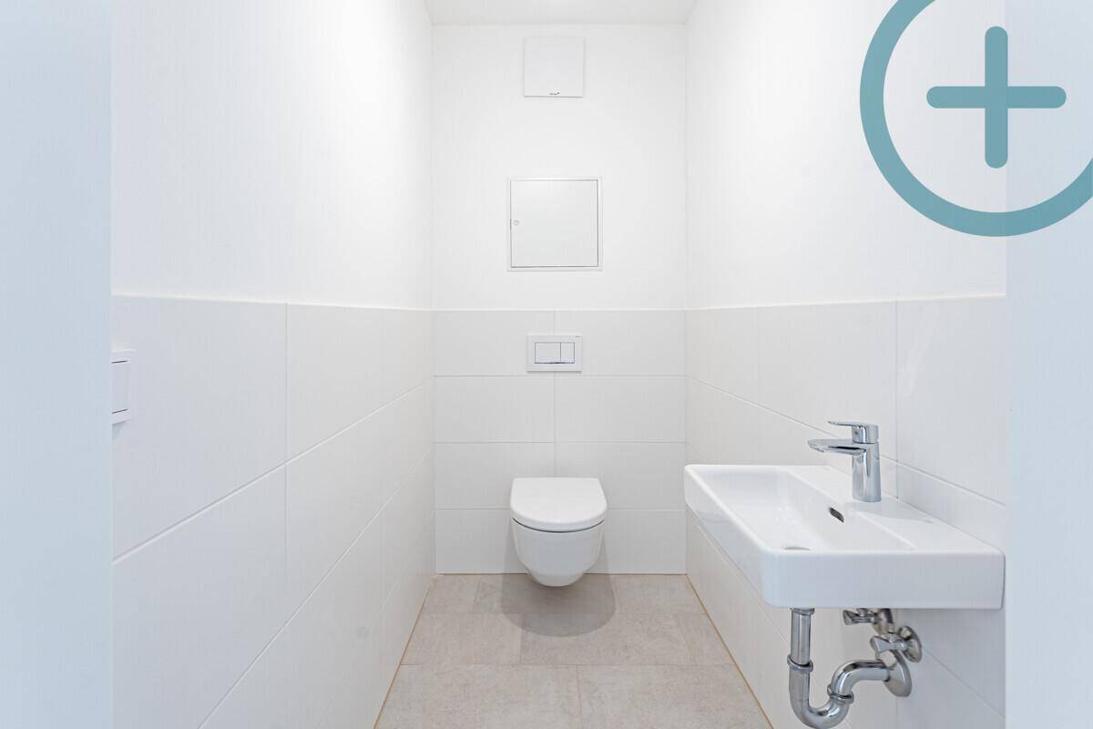 Separates Gäste-WC mit wandhängendem WC und kleinem Waschbecken in modernem Design.