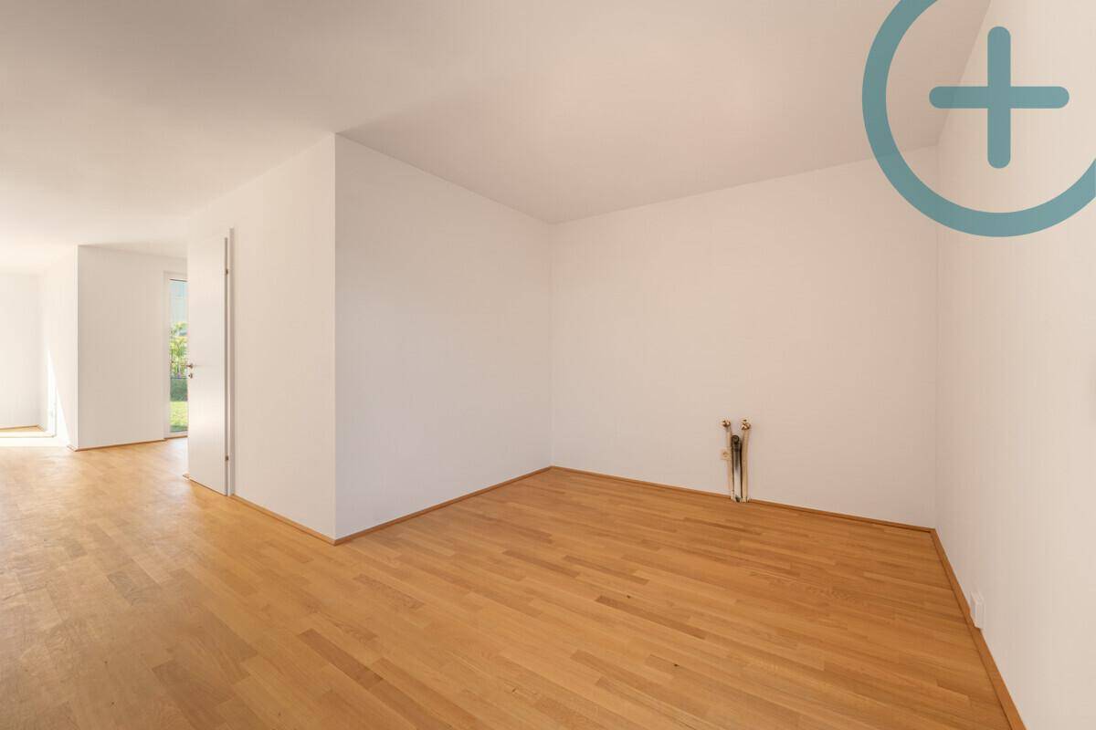 Leerer Raum mit Parkettboden und Anschlüssen an der Wand, bereit für die Einrichtung.
