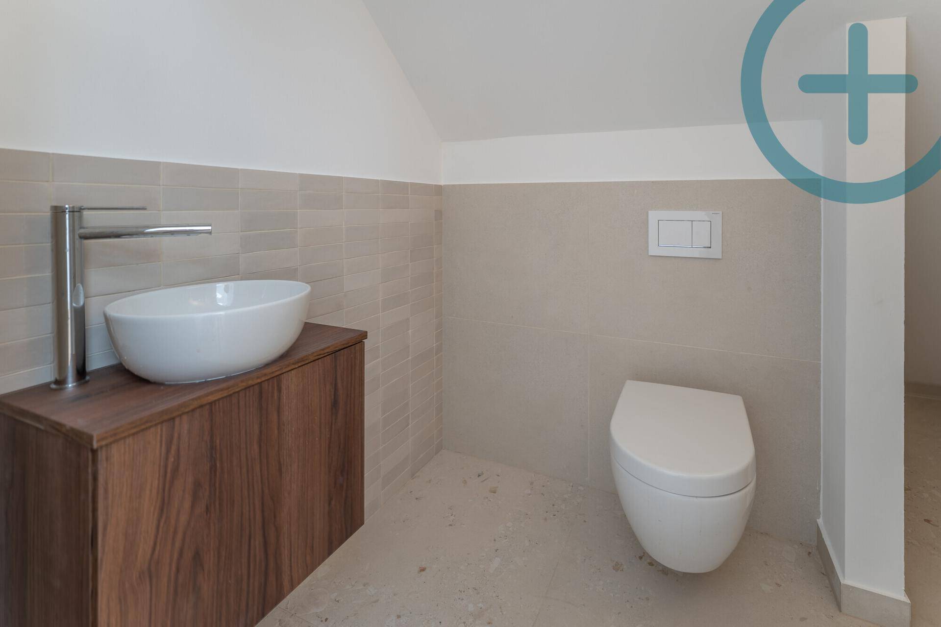 Modernes Badezimmer mit Aufsatzwaschbecken, Wand-WC und beigefarbenen Fliesen.