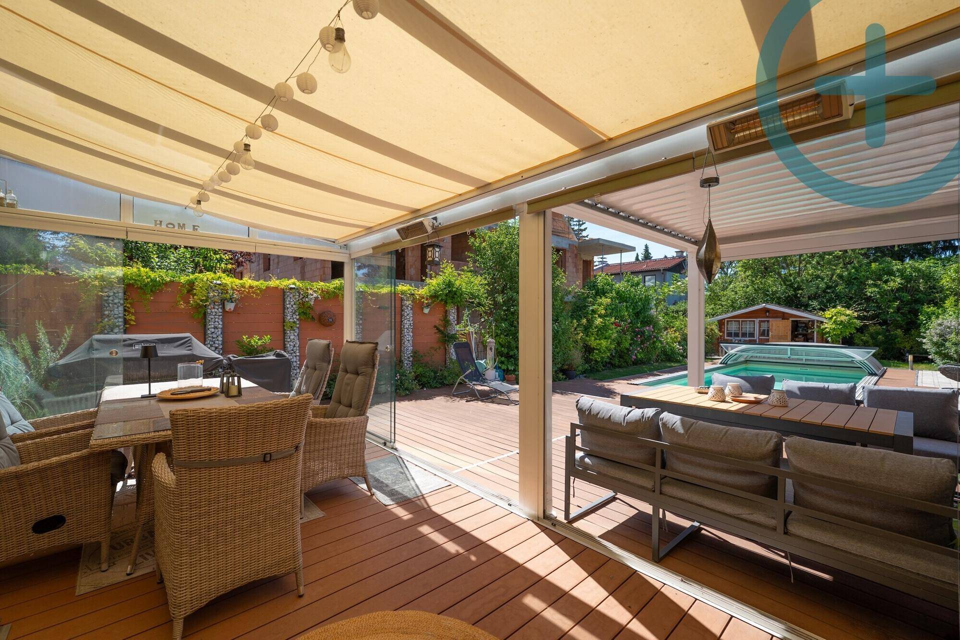 Überdachte Terrasse mit gemütlichen Sitzgelegenheiten und direktem Blick auf den Poolbereich.