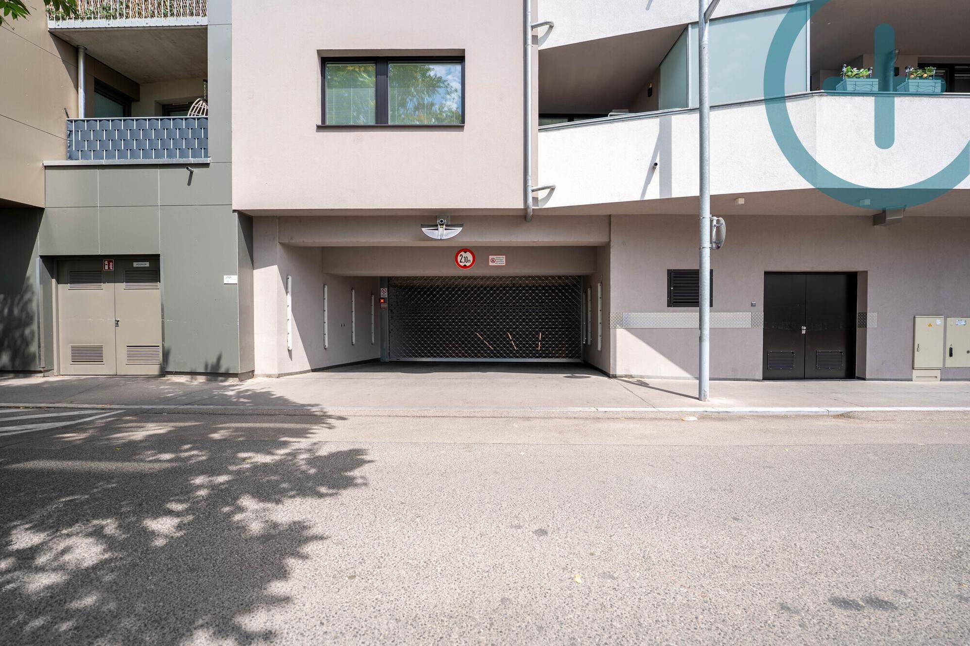 Eingang zur Tiefgarage eines modernen Wohngebäudes mit geschlossenem Rolltor.
