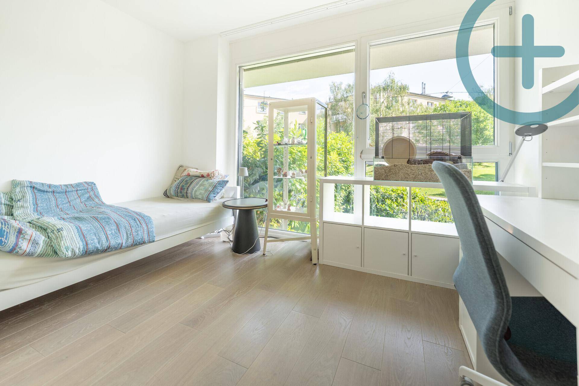 Kinderzimmer oder Gästezimmer mit Einzelbett, Schreibtisch und großen Fenstern zum Garten.