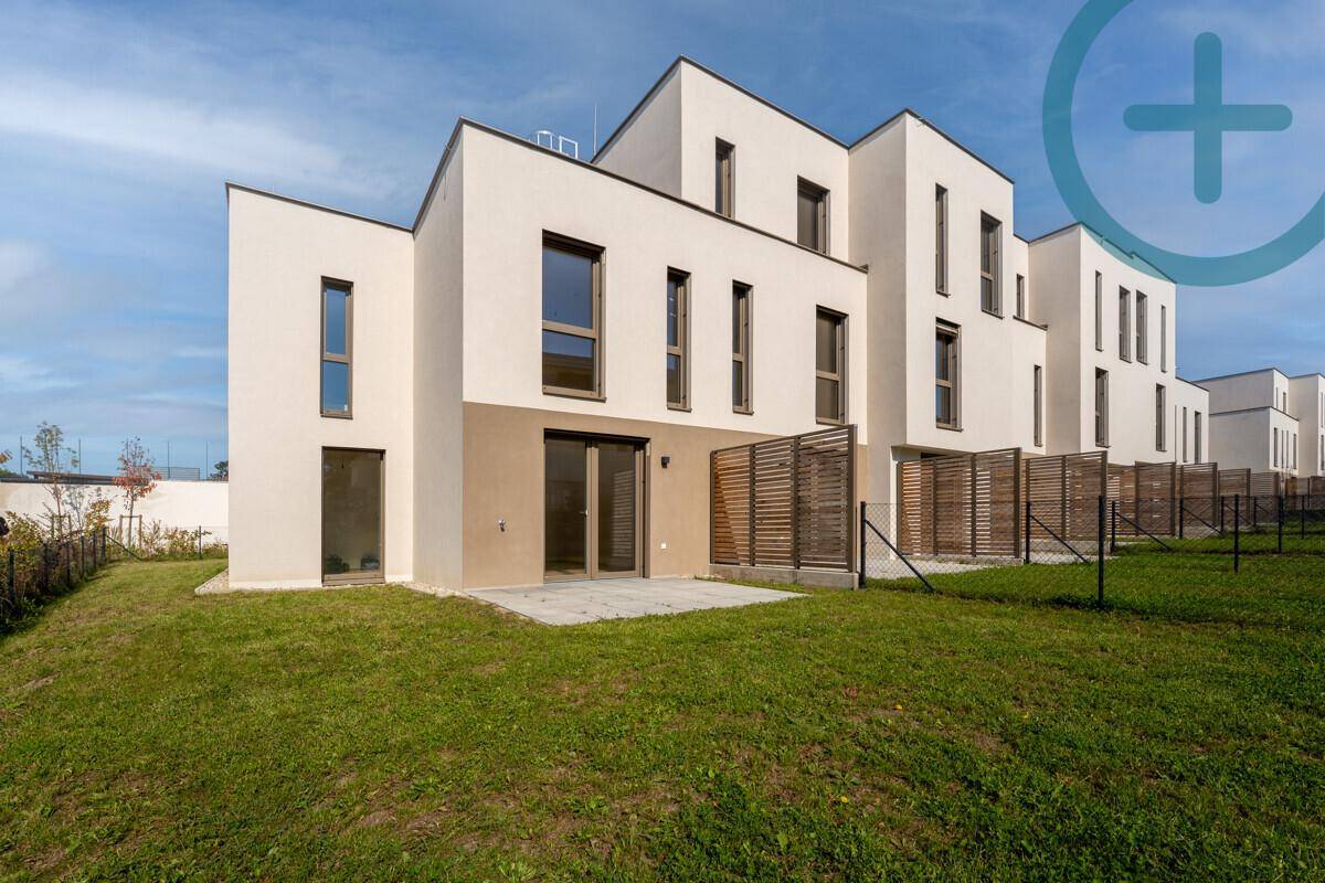 Moderne Reihenhäuser mit privatem Garten und Terrasse, umgeben von Grünflächen.