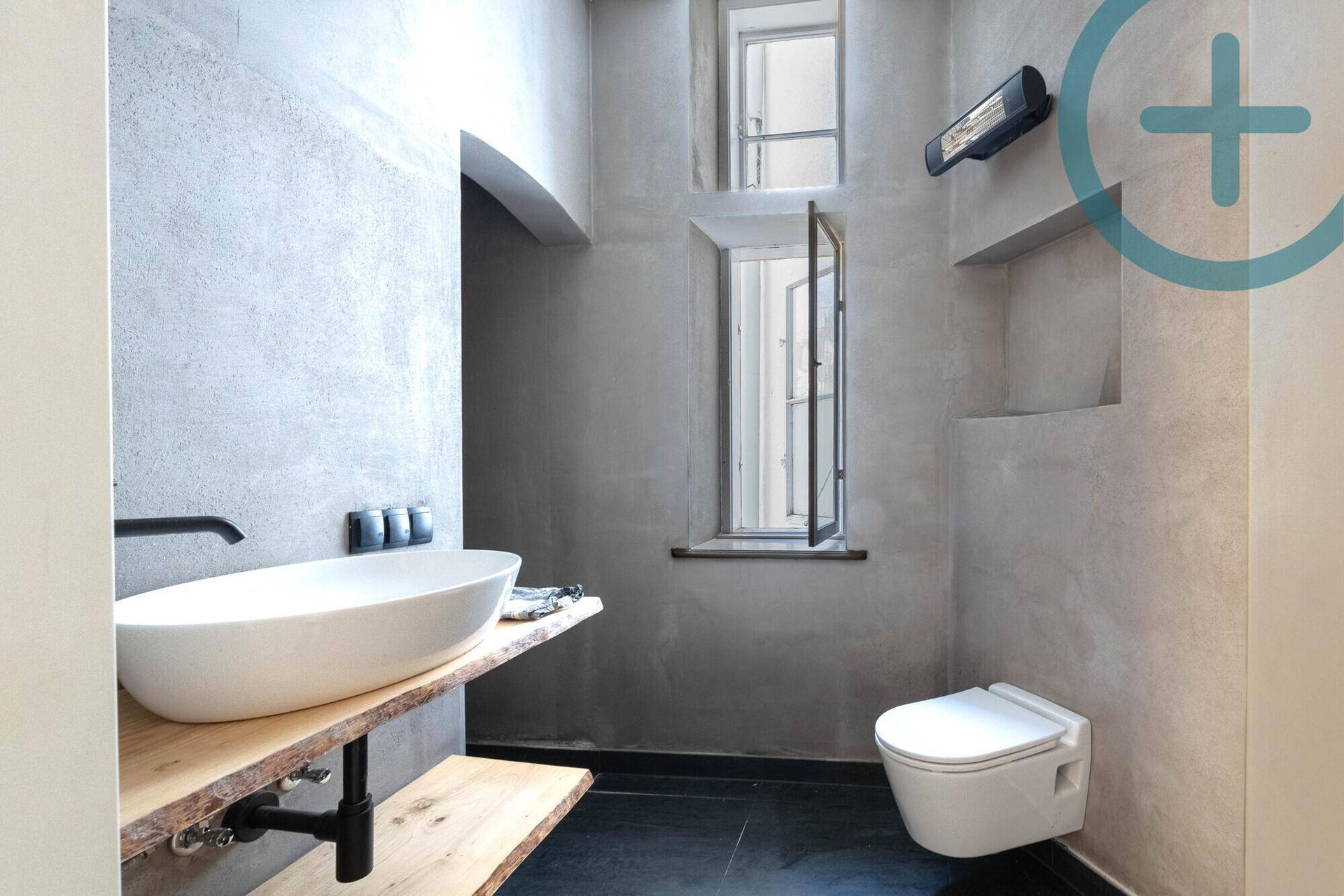 Modernes WC mit Aufsatzwaschbecken, Wand-WC und minimalistischem Design.