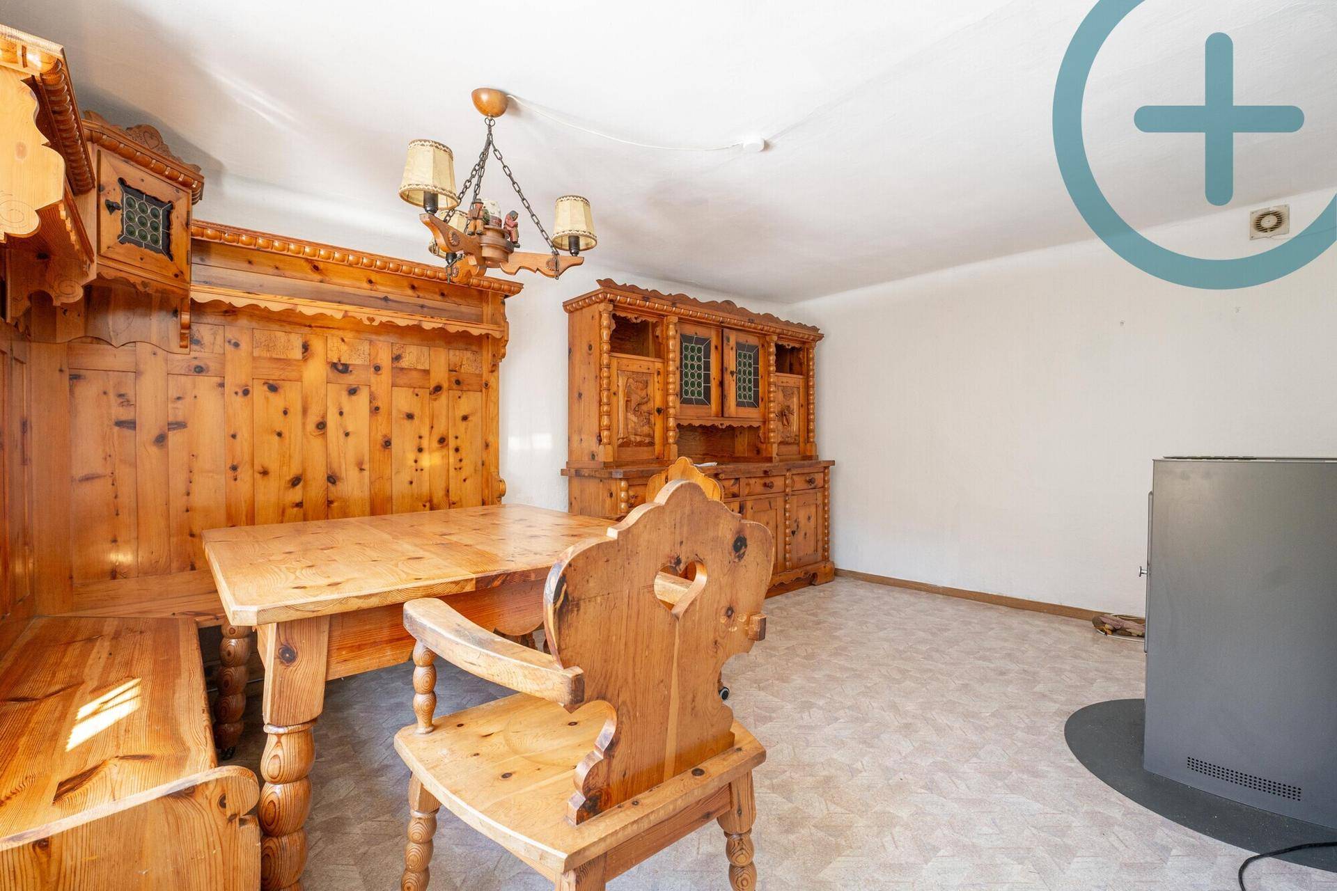 Rustikaler Essbereich mit traditionellen Holzmöbeln und einem Kaminofen im Landhausstil.