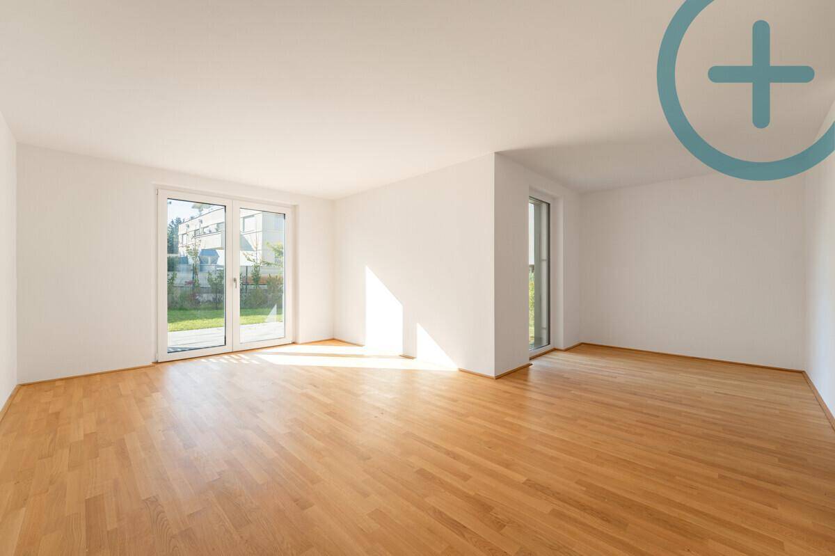 Lichtdurchfluteter Raum mit Holzboden und direktem Zugang zu einem Außenbereich.