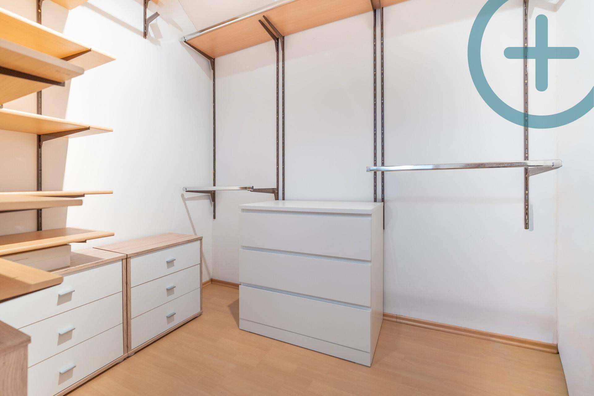 Praktischer begehbarer Kleiderschrank mit Regalen und Kommoden für viel Stauraum.