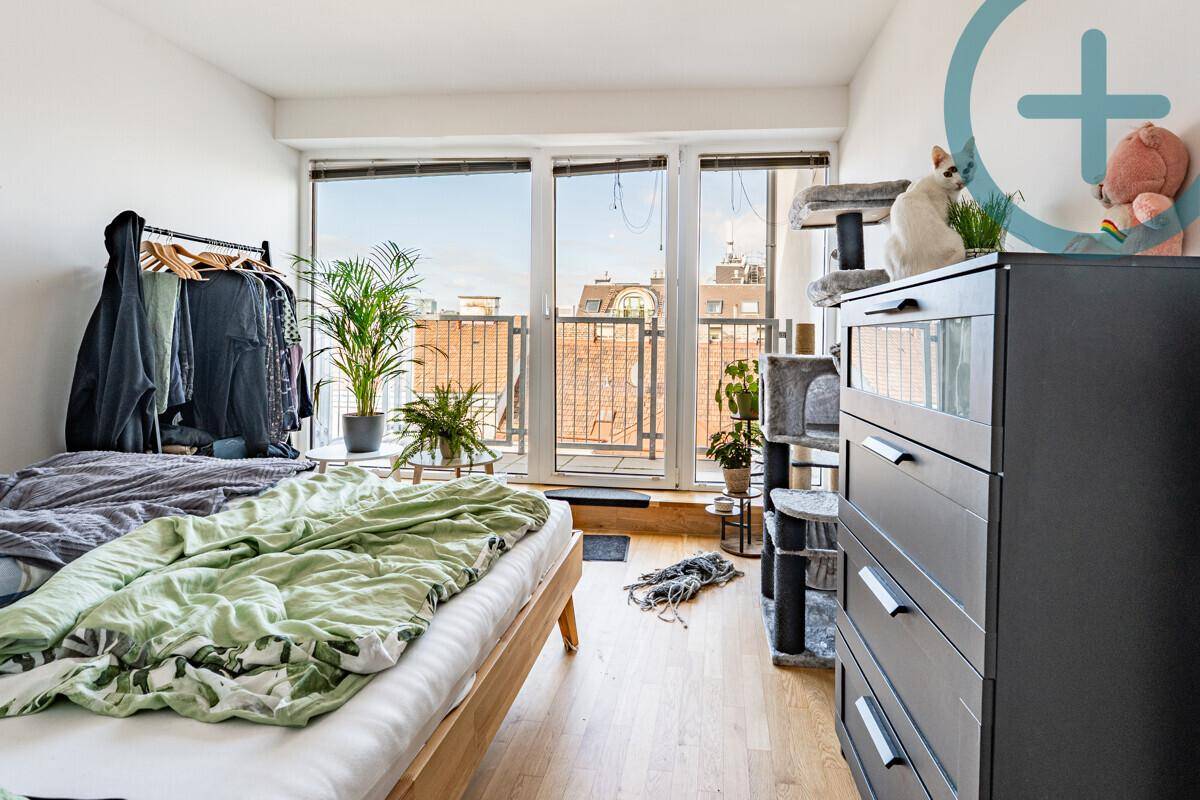 Gemütliches Schlafzimmer mit Holzboden, großen Fenstern und Zugang zu einem Außenbereich.