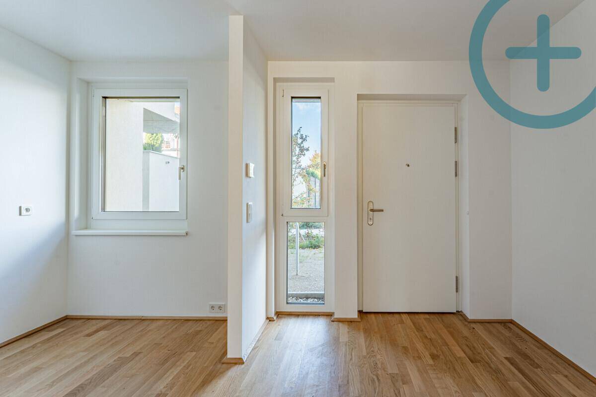 Eingangsbereich mit Holzboden und Fenster, das Tageslicht in den Flur bringt und einladend wirkt.