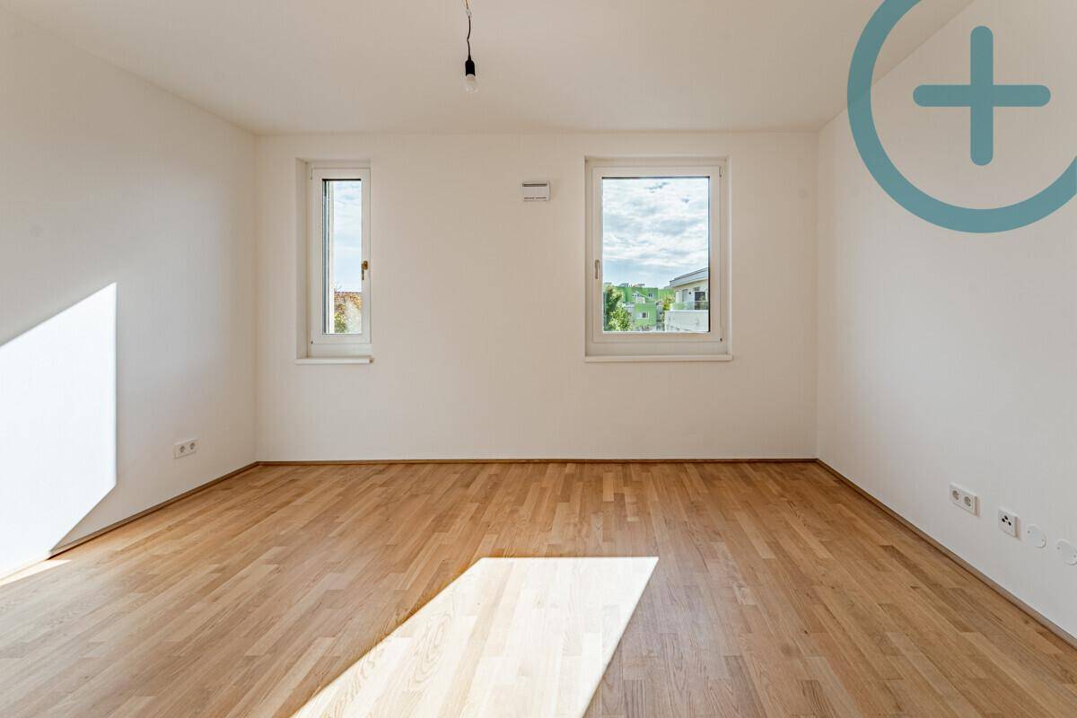 Lichtdurchflutetes Zimmer mit Parkettboden und Ausblick, perfekt für ein ruhiges Schlafzimmer.