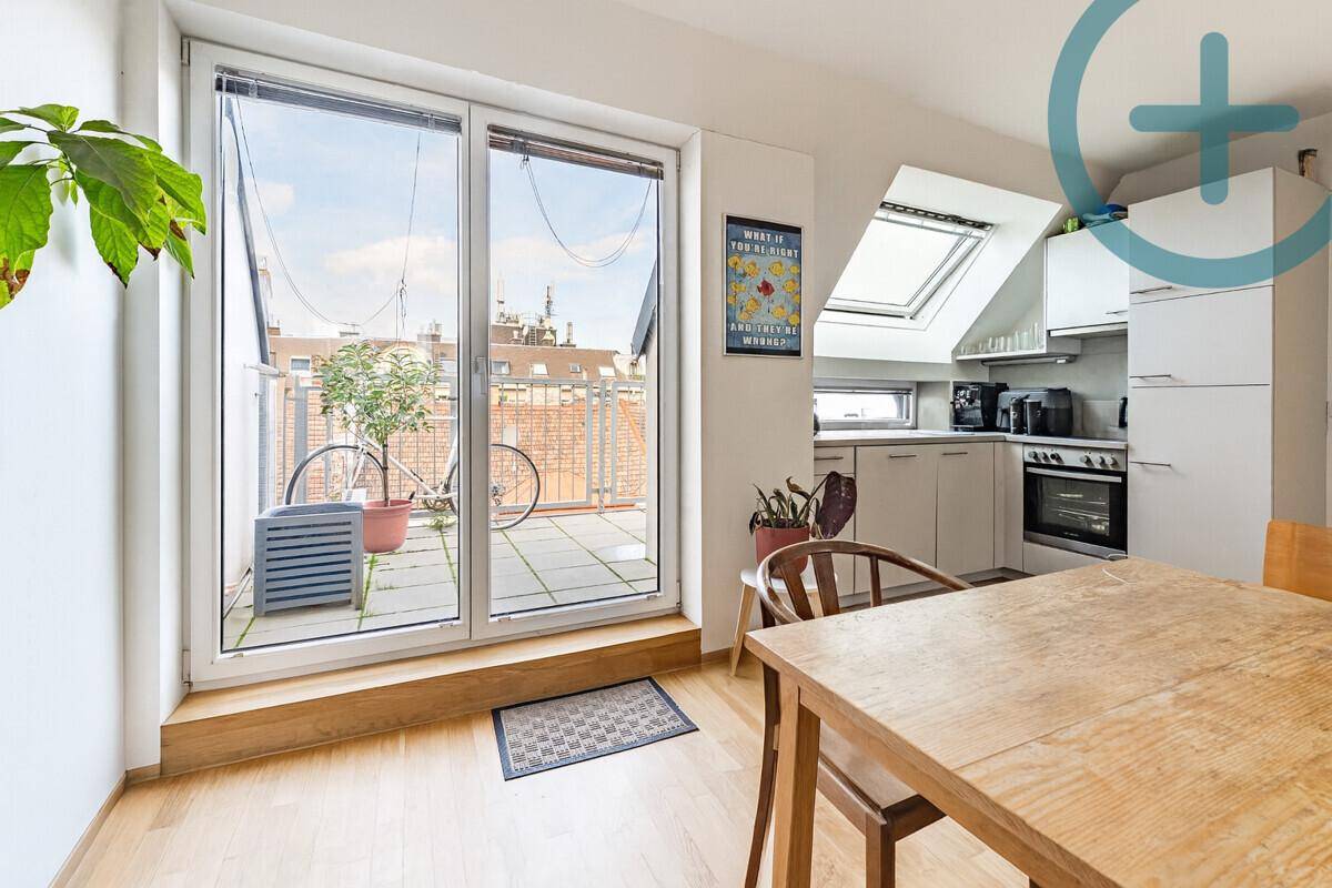 Lichtdurchfluteter Wohnbereich mit offener Küche, Esstisch und direktem Zugang zur Dachterrasse.